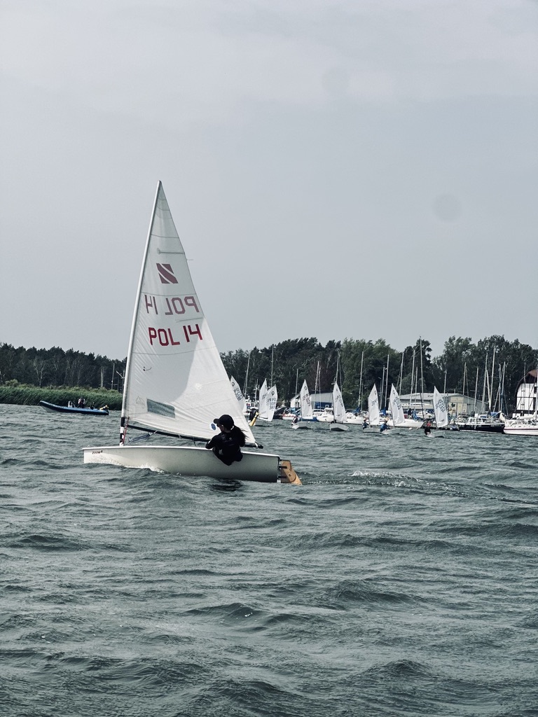Żeglarz na łodzi ILCA POL 14 płynący w kierunku floty