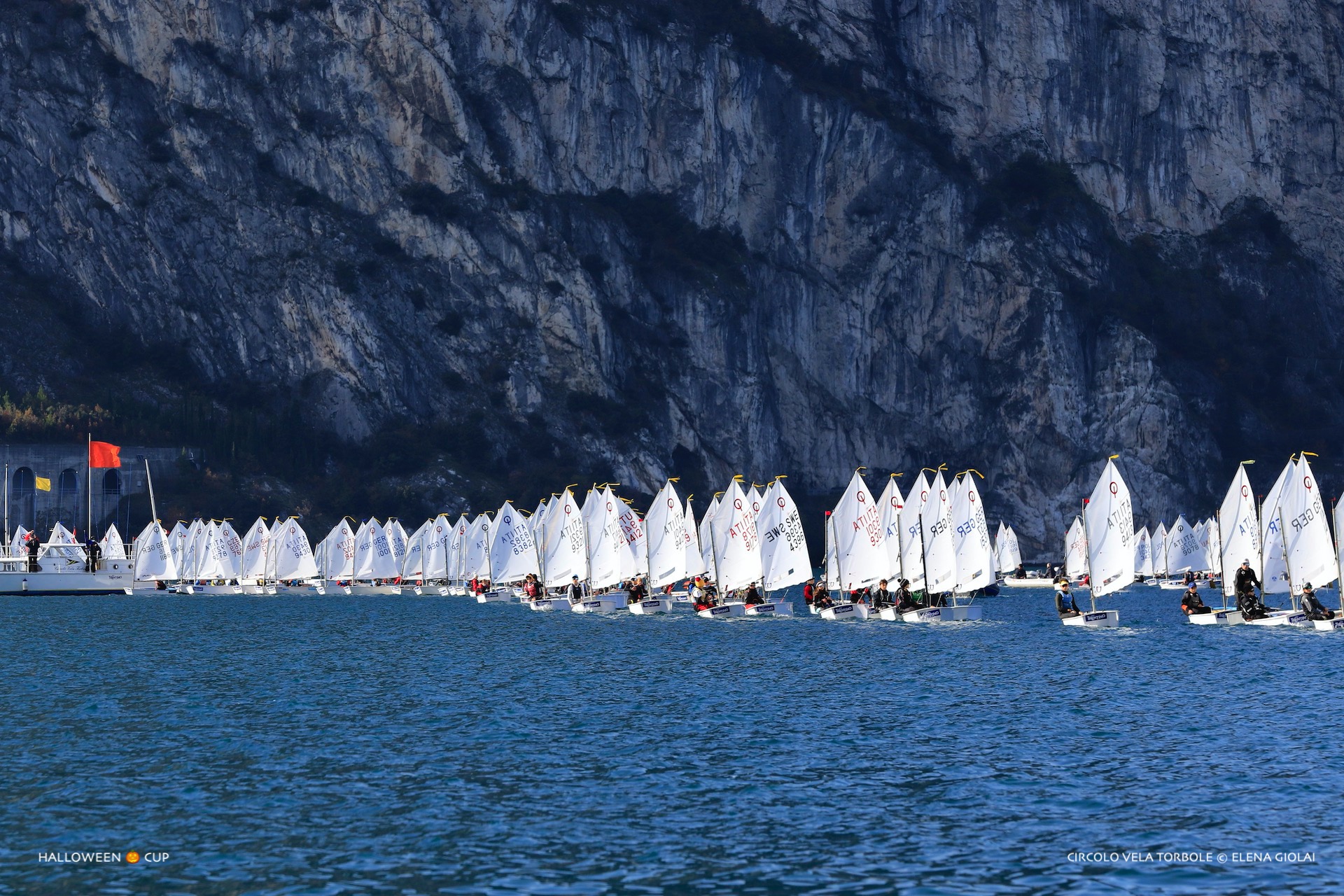 Flota żaglówek Optimist podczas regat Halloween Cup na jeziorze Garda